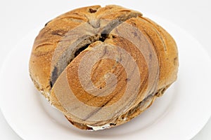 New York City Cinnamon Raisin Bagel filled with Cream Cheese on a White Plate