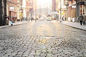 New York City - Cobblestone street view in Soho with bright sunlight background photo