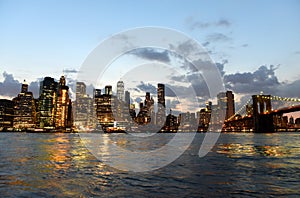 New York City, financial district in lower Manhattan with Brooklin Bridge at night, USA