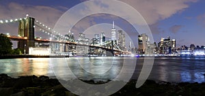 New York City, financial district in lower Manhattan with Brooklin Bridge at night, USA