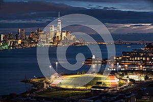 New York City Financial District skyscrapers at night with the Hudson River and Weehawken, New Jersey. World Trade Center photo