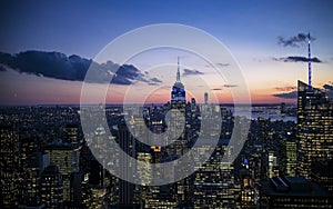 New York City. Manhattan downtown skyline with illuminated Empire State Building and skyscrapers at dusk.