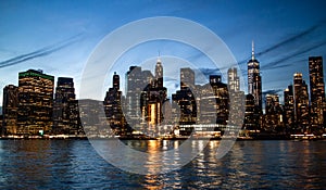 New York City. Manhattan downtown skyline with illuminated Empire State Building and skyscrapers at dusk.