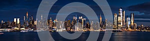 New York City Manhattan view at dusk from the Hudson River. The view includes the skyscrapers of Midtown West Hudson Yards