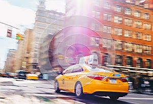 New York City - March 20, 2017 : Yellow taxi cab speeds down in a New York City Street. Shot with long shutter speed for