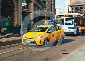 New York City - March 20, 2017 : Yellow taxi cab speeds down in a New York City Street. Shot with long shutter speed for