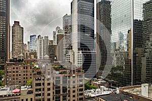 New York City midtown Manhattan skyline view with skyscrapers and cloudy sky in the day.