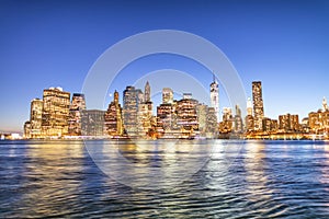 New York City night lights. Lower Manhattan skyline from Brooklyn Bridge Park promenade - USA