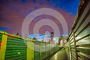 NEW YORK CITY, NY - JUNE 14th, 2013: Brooklyn Bridge and tourists at night