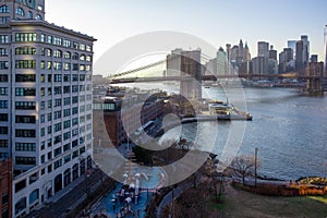 New York City skyline with skyscrapers at sunset. Brooklyn bridge as a connection between Manhattan and Brooklyn