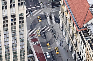 New York city street with yellow taxis and people walking. Cabs, cars and pedestrians crossing crosswalk. Busy NYC Downtown.