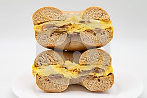 New York City Style Spelt Bagel with Bacon Eggs and Cheese on a White Plate