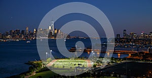 New York City. View of the soccer field and Manhattan skyline from Weehawken, NJ, at dusk.