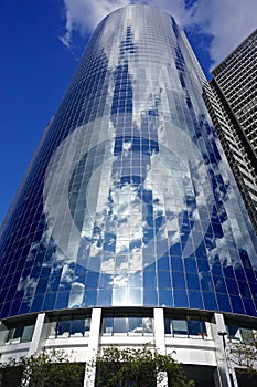 New York, New York: Clouds in a blue sky reflected in the steel and glass facade of a modern skyscraper