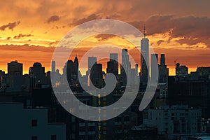 New York Lower Manhattan sunset skyline view from Brooklyn with dramatic sky and clouds over roofs