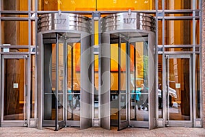 New York, Manhattan downtown. Revolving doors on glass building facade