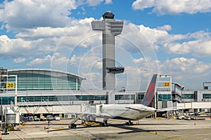 Air Traffic Control Tower and Delta Airlines plane on tarmac at Terminal 4 at JFK International Airport
