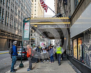 Unidentified migrants in front of New York City's new migrant welcome center at the former four-star Roosevelt Hotel