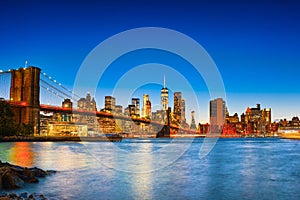 New York night view of the Lower Manhattan and the Brooklyn Bridge across the East River.