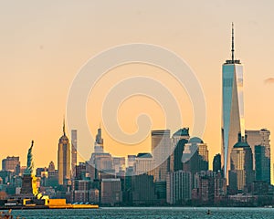 Horizontal sunrise view of the Statue of Liberty in the New York Harbor, with the skyline of