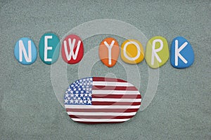 New York, souvenir composed with hand painted multi colored stone letters and a USA flag over green sand