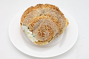 New York Style Sesame Seed Bagel with Scallion Cream Cheese on a White Plate
