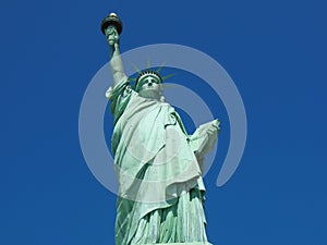 View of the Statue of Liberty against the background of the blue sky.