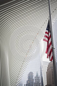 NEW YORK, USA - FEBRUARY 23, 2018: American flag at half mast under an architectural wing of the Oculus at the center of Wall