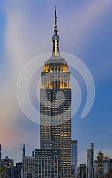 Manhattan downtown skyline with illuminated Empire State Building and skyscrapers at sunset, New York, USA