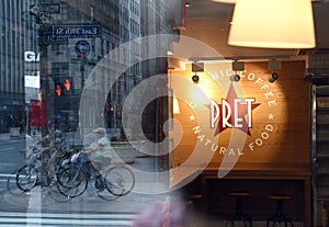 New York, USA - May 26, 2018: Fast casual restaurant Pret A Manger logo with reflection the street of New York.