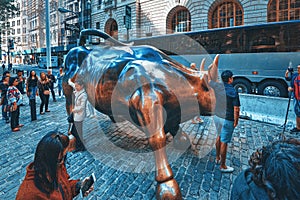 Monument of Charging Bull Financial on Broadway, near Wall Street in the New York with people and tourists