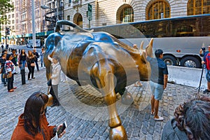 Monument of Charging Bull Financial on Broadway, near Wall Street in the New York with people and tourists.