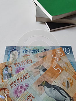 New Zealand banknotes and stacked books