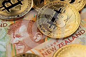 New Zealand Dollar bill with Bitcoin BTC Cryptocurrency coins.