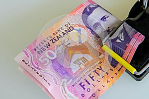 New Zealand fifty dollar notes caught in a mouse trap.