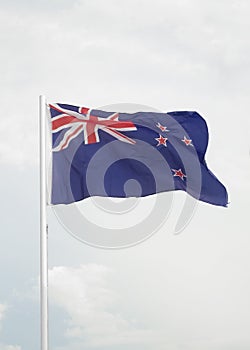 New Zealand flag on blue sky with clouds background