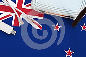 New Zealand flag depicted on table with internet rj45 cable, wireless usb wifi adapter and router. Internet connection concept