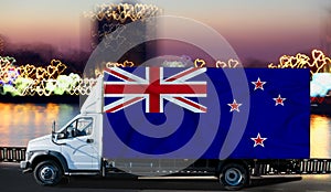 New Zealand flag on the side of a white van against the backdrop of a blurred city and river. Logistics concept