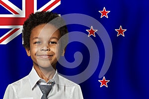 New Zealand kid boy on flag of New Zealand background. Education and childhood concept