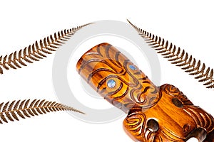 New zealand symbol, traditional maori carving and silver fern leaves, white background, close up