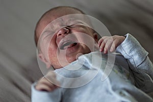 Newborn 1 week old baby is crying. Love and tenderness. Close-up