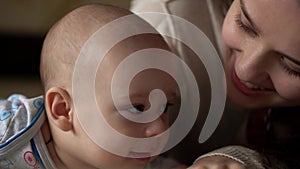 Newborn Active Baby With Young Mom. Cute Smiling Teethless Face Portrait Early Days On Stomach Developing Neck Control