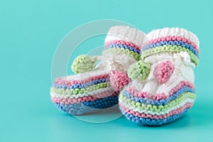 Newborn announcement. knitted baby booties on plain blue backgro