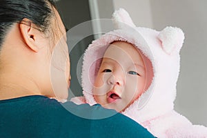 A newborn Asian baby boy in the mother`s embrace, Charming black-eyed baby 4 month old smile and happy ,A cute child hug his