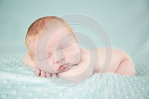 Newborn baby boy against green background