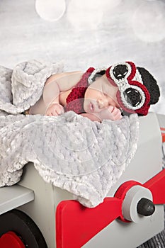 Newborn baby boy in aviator outfit in a plane