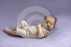 Newborn baby boy on blue textile background.