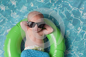 Newborn Baby Boy Floating on an Inflatable Swim Ring