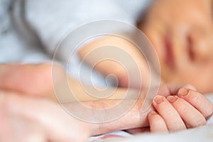 newborn baby boy holding finger of parent