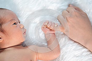 Newborn baby boy holding little finger of mother`s hand